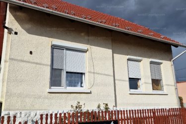 A kertvárosi tégla épület alapozása beton és terméskő. Nagy részben új tetőszerkezet. Hőszigetelt ablakok és falak.
 A külön bejáratú akadálymentes földszinten (100 m2) két kis előszoba-belépő, 2 szoba, konyha-étkező, egy és élelmiszer raktár, fürdőszoba, wc, káddal, 1 félszoba külön bejárattal wc-kézmosóval.
A félemeleten (kilenc lépcső,76 m2) 2 szoba, konyha, hall-étkező és nagy fürdőszoba-káddal, wc, bide van. 
A félszuterénben (jelenleg iroda, konditerem lakható állapotban, öt lépcső, 76 m2) előszoba, 2 szoba, raktár és a tüzelőtároló-kazántér van. A rézcsövekkel szerelt központi-fűtésrendszer automata gázkazánnal vagy a szilárd tüzelésű kazánnal is működtethető.
A félemelet fölötti tetőtér is (tisztán 35 m2) beépíthető.

A telek 605 m2 kb. 100 m2 kerttel. Az udvar gyeprácskővel burkolt itt 125 m2 fedett kocsibeállók (2-5 autó) valamint raktár van. A ház négy bejárata miatt alkalmas vendégháznak és egyéb vállalkozások számára is kiváló. 

Az utca aszfaltburkolatú kis forgalmú, csendes, rendezett. Református templom, szupermarket, iskola-óvoda, orvosi rendelők, könyvtár, városi buszmegállók 100-150 m. 